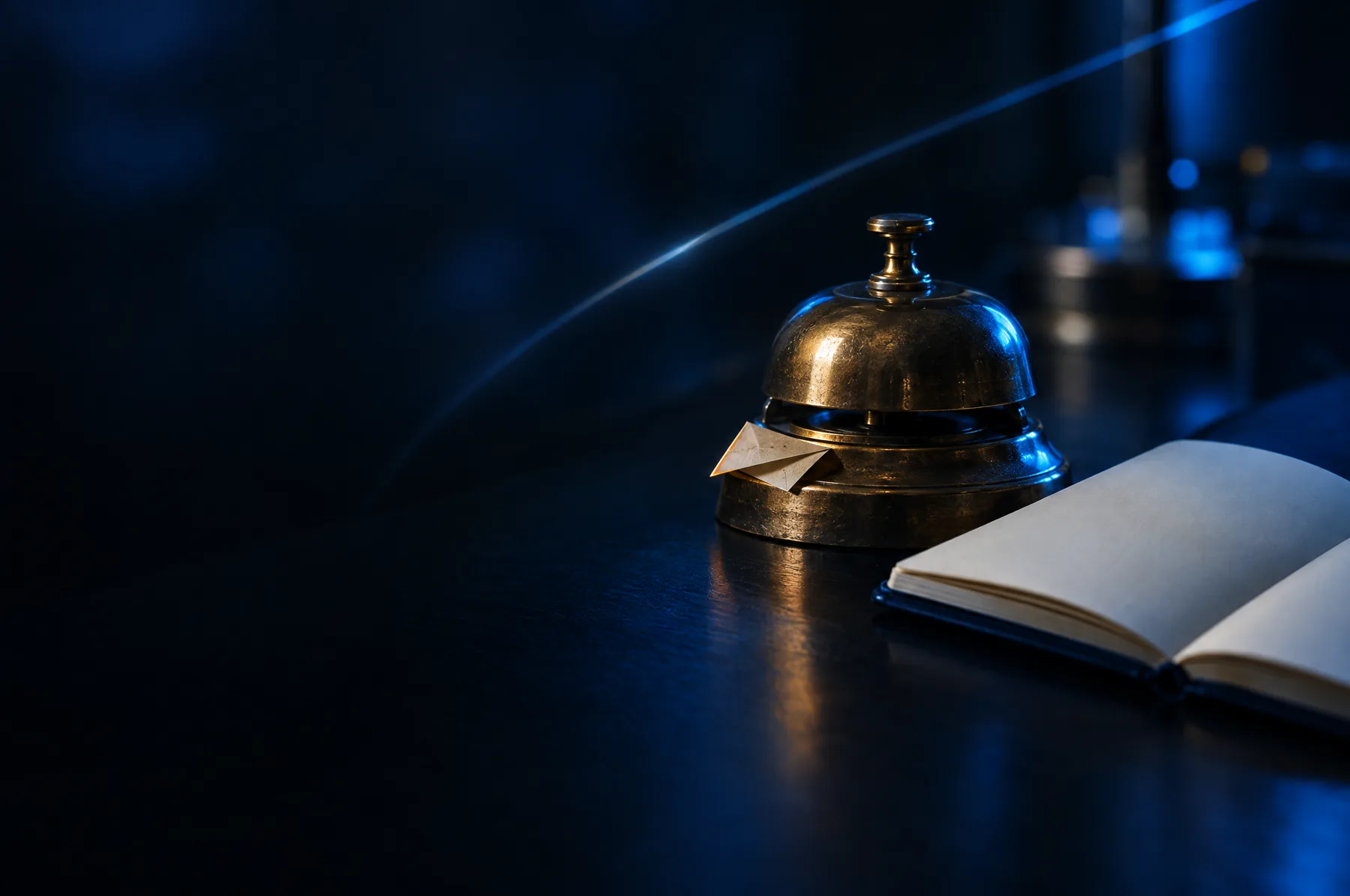 Vintage service bell with a small paper airplane next to an open blank notebook on a dark reflective surface